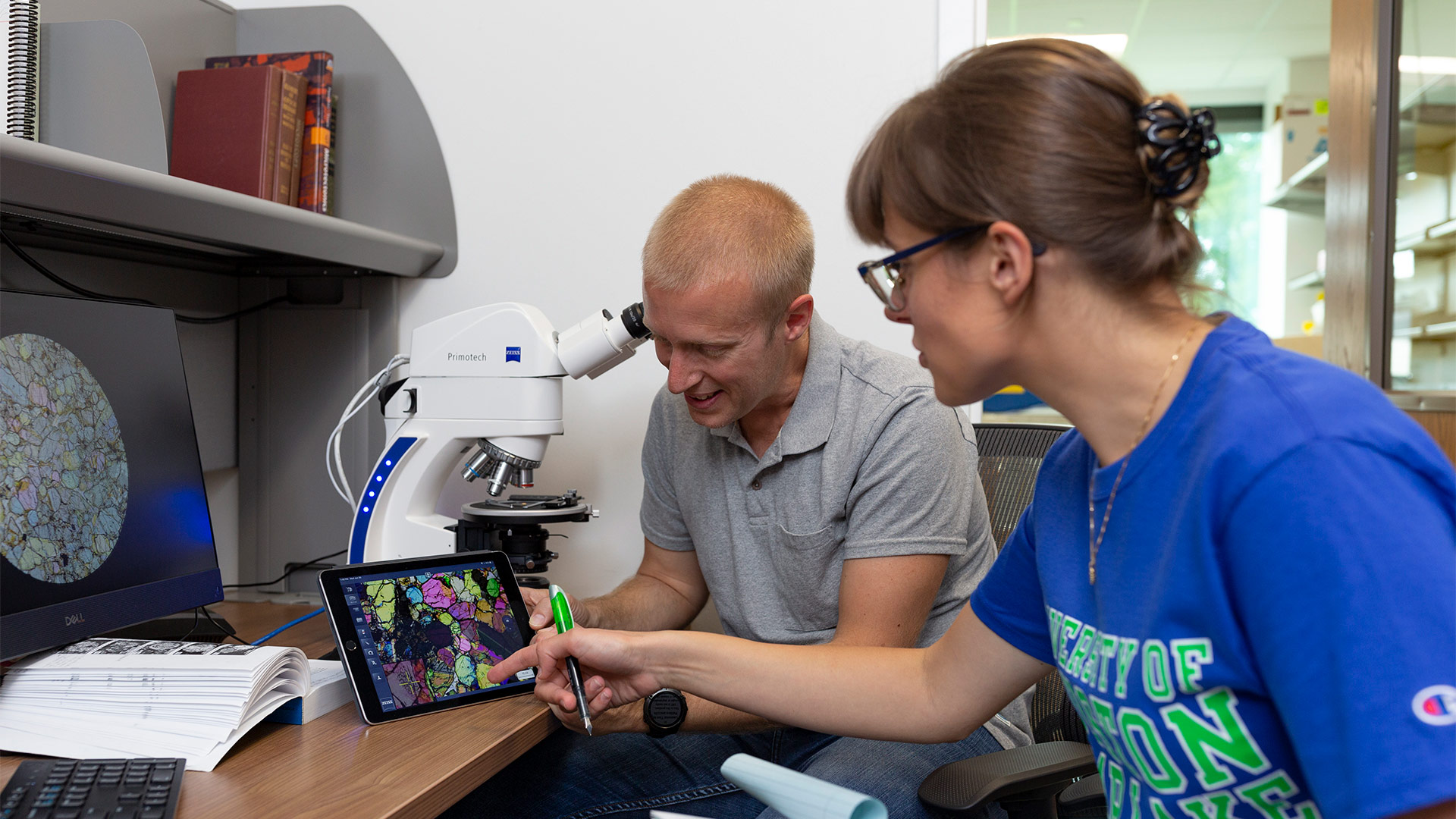 Dr. Daniel Imrecke and research assistant Ane Slabic examine an analysis on a tablet