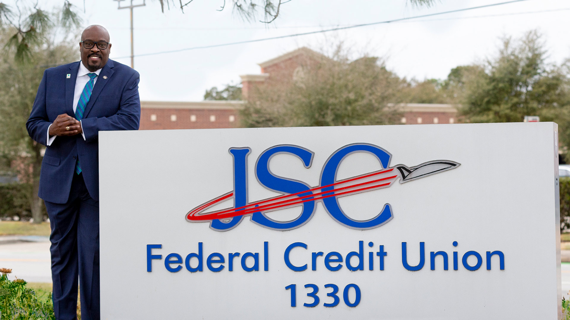 Busby with the JSC Federal Credit Union sign