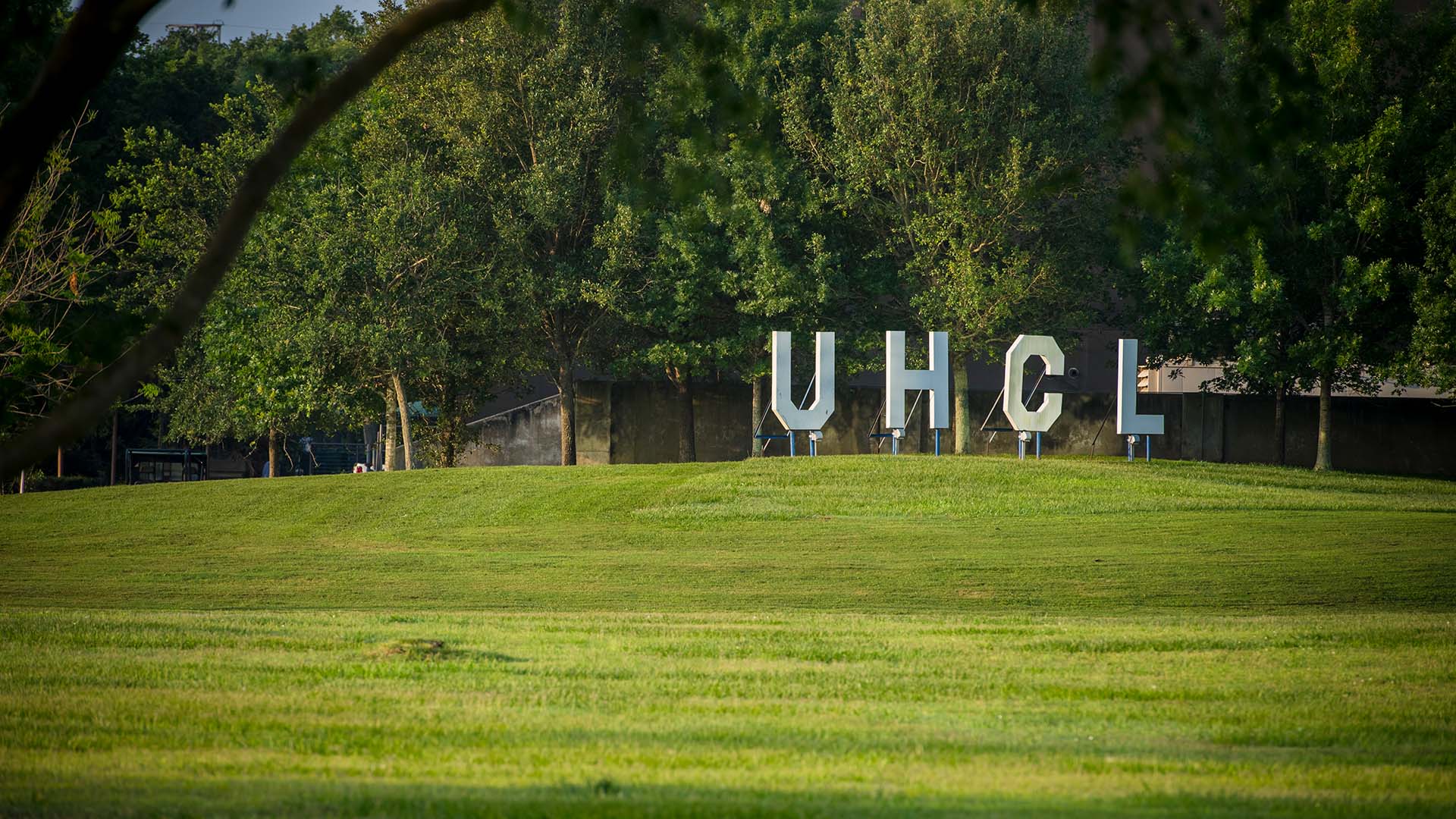 The white UHCL letters stand on a hill on campus