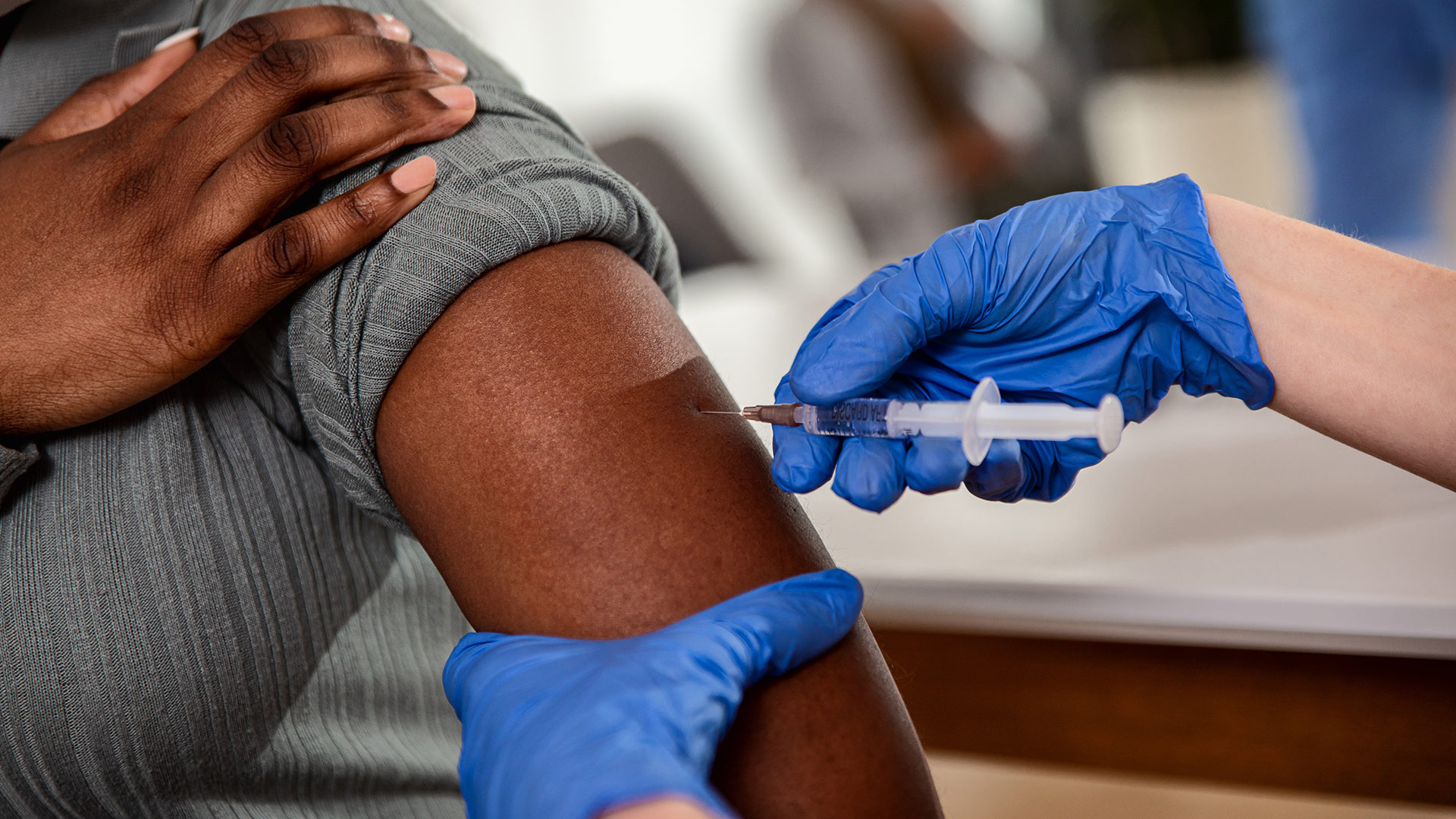 A person receives an injection in their arm