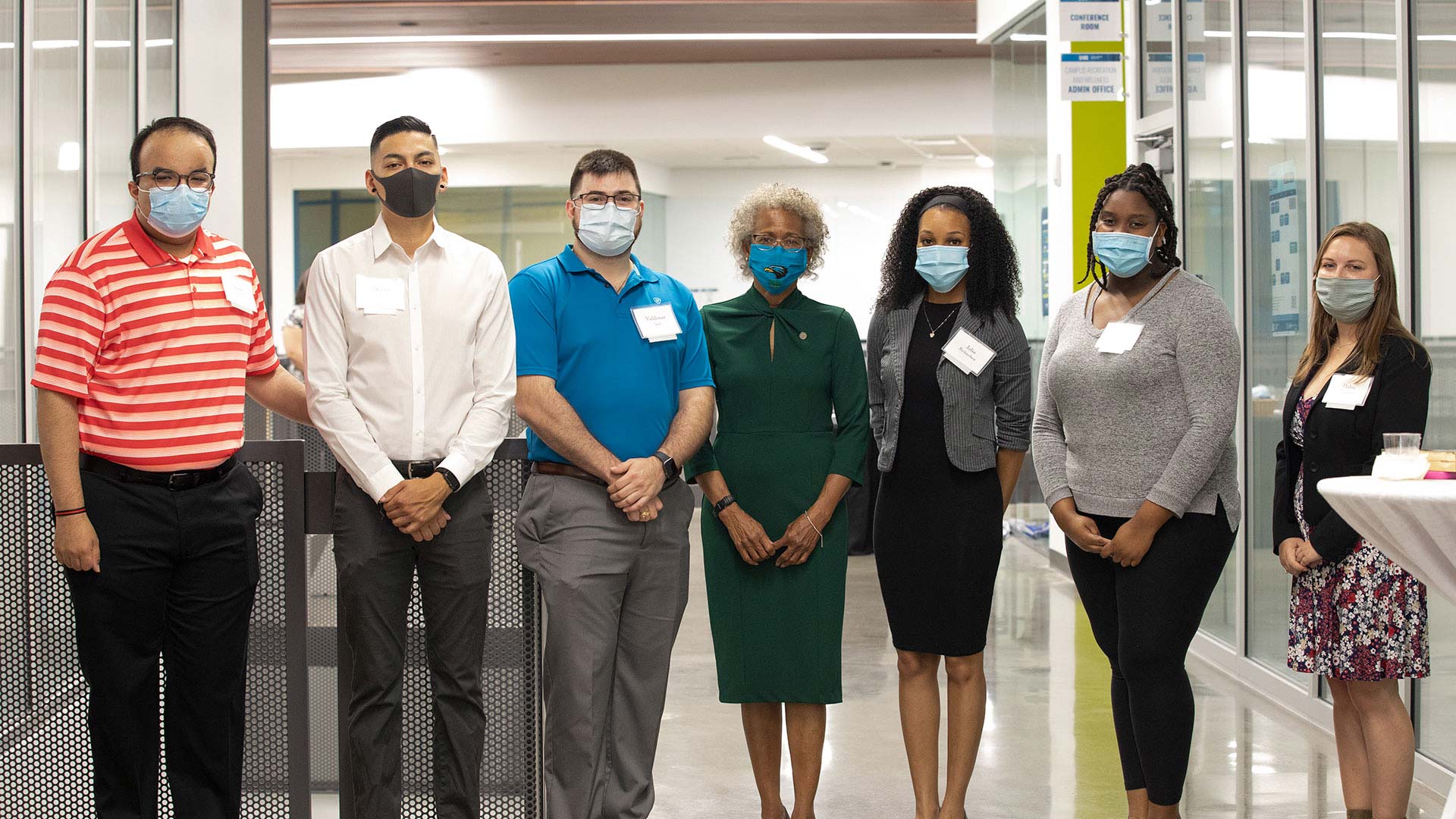 Masked students and President Ira K. Blake gather on the UHCL campus