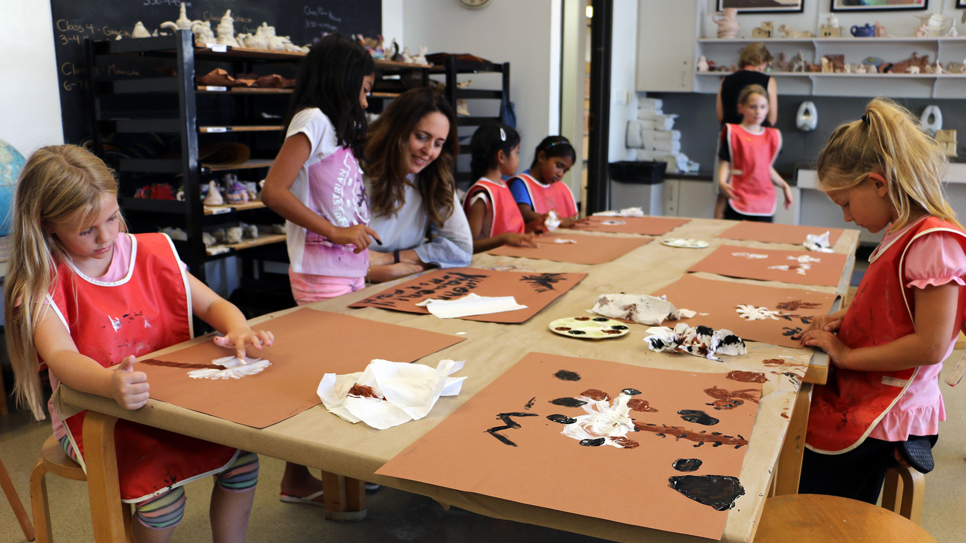 Elementary students participating in an art project with an instructor