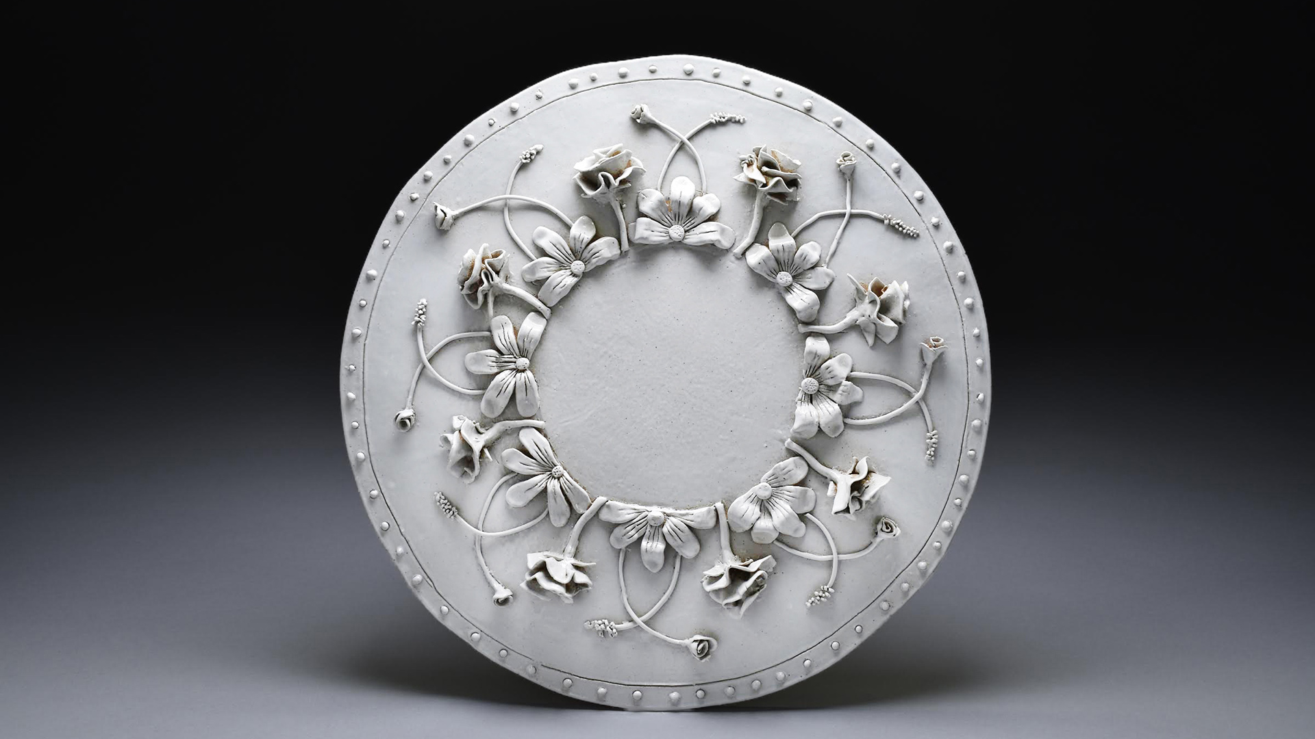 A pale ceramic plate decorated with twining flowers and vines